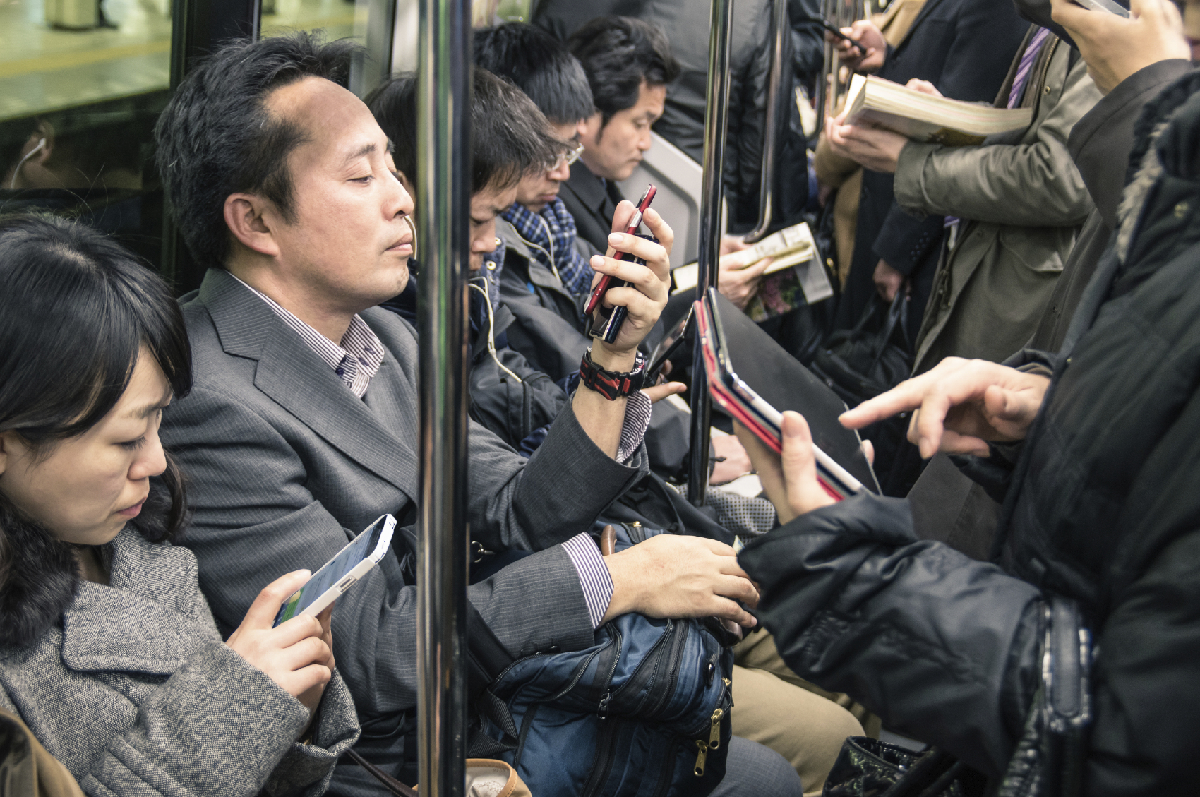 TOKYO -MARCH 2, 2015: people busy with smartphones and tablets i