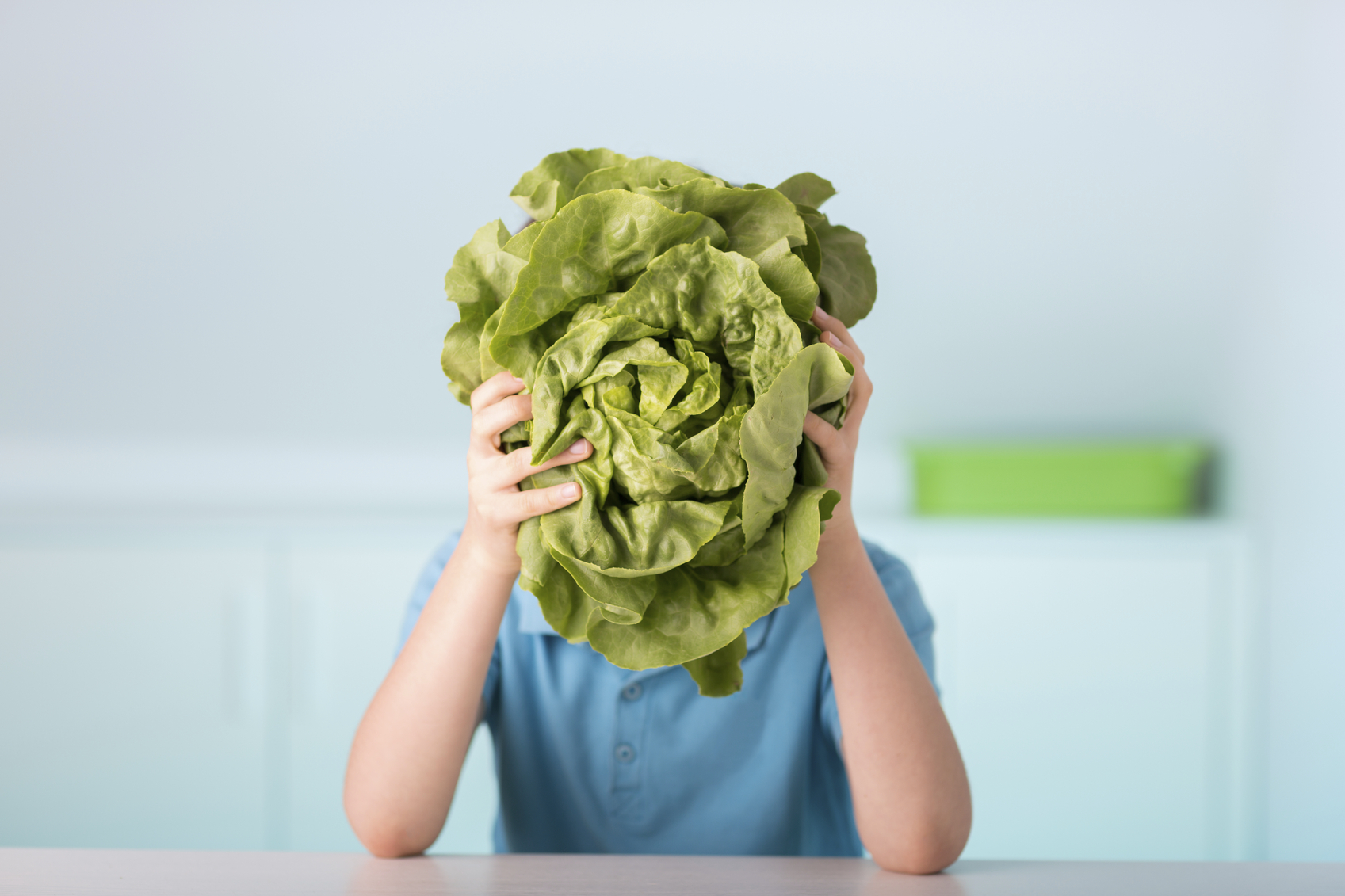 one 9 years old boy with green lettuce